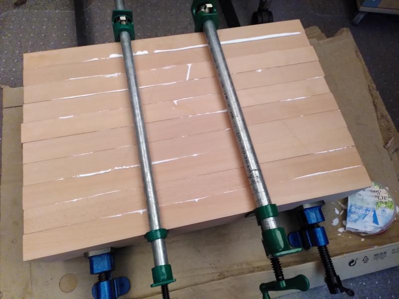 Beech wood being glued together to form a block. There are 4 clamps, 2
top, 2 bottom, and white glue is squeezing out each of the joints. It's
all sat on a peice of cardboard
