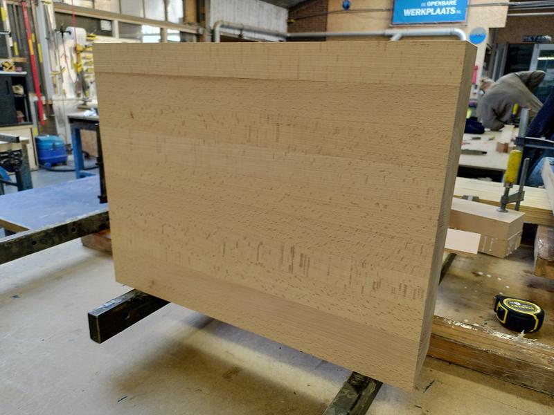 A block of beech sat on it's side vertically it's 500mm wide, 400mm
high, and 100mm thick. It's stood on a pair of tape covered wooden blocks.
There's various workbench clutter behind it.